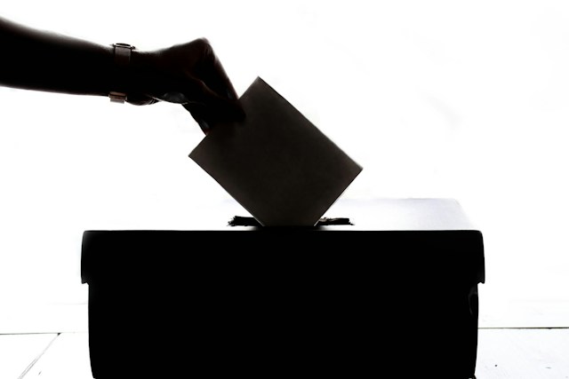 A person casting a vote in a ballot box